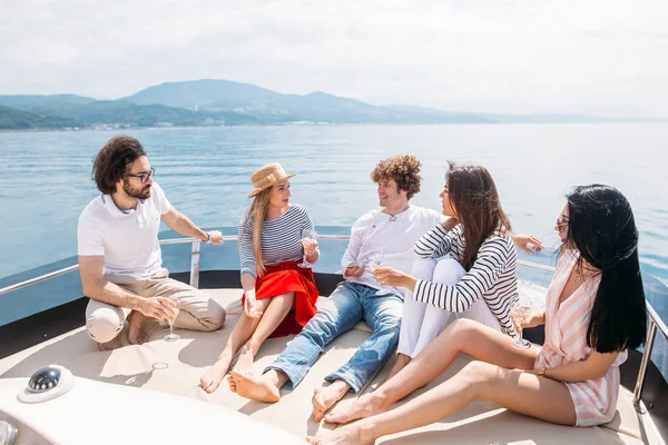 Amigos se divertindo velejando em um iate no mar, rindo, conversando e refrigeração — Fotografia de Stock