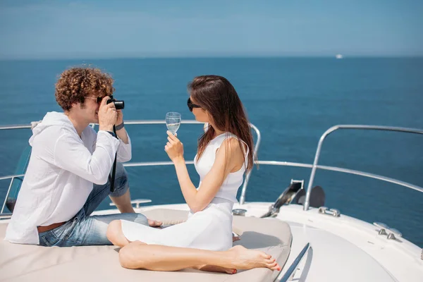 Atraktivní pár na jachtě. Mladý muž fotí svou přítelkyni. — Stock fotografie