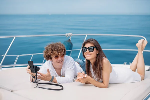 Attractive couple on the yacht. Young man is taking photo of his girlfriend — Stock Photo, Image