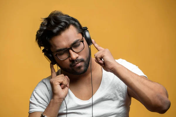 Close up portrait of good-looking Indian model enjoying listening to the music — Stock Photo, Image