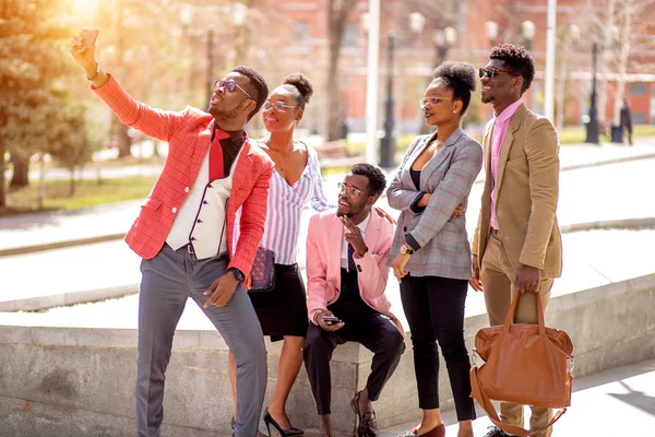 Guapo encantador hombre está tomando una foto con sus colegas al aire libre —  Fotos de Stock