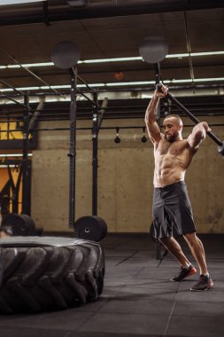 güçlü vücut geliştirmeci traktör vurmak için büyük çaba sarf IA lastik