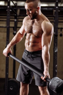 Elindeki çekiçle atlet ter.