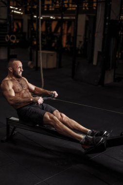 dayanıklılık concept.young güçlü bir adam ile kapalı kürekçi egzersizleri yapıyor