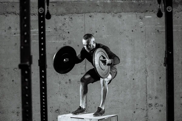 Photo en noir et blanc. forme magnifique homme travaille avec des plaques de poids — Photo