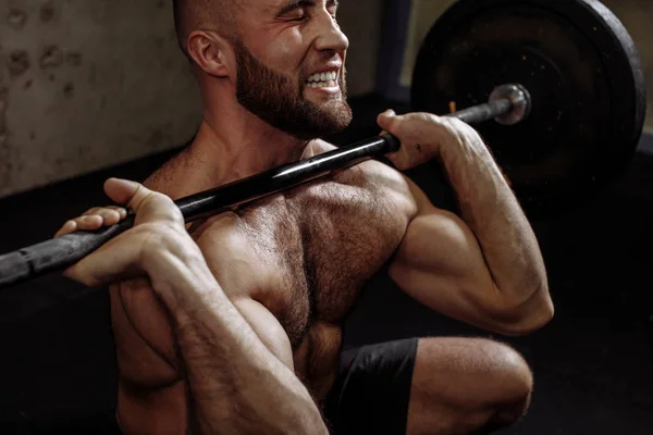 Angry sportsman with clenched teeth using a barbel in training. — Stock Photo, Image