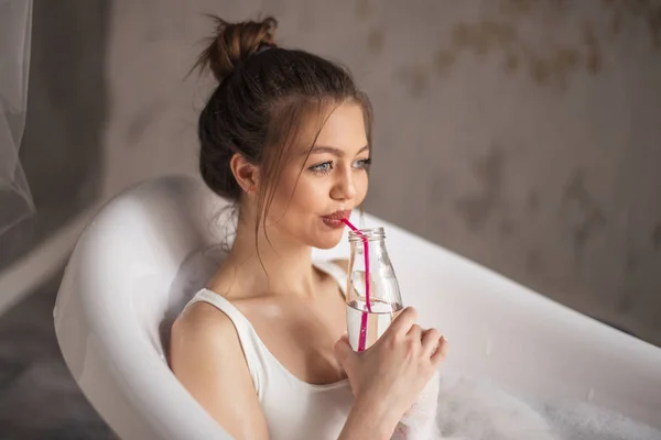 Agradable mujer sorbiendo agua en el vaso — Foto de Stock