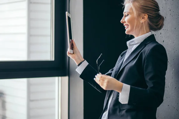 Positives Mädchen beim Fotografieren im Büro mit modernem Interieur. — Stockfoto