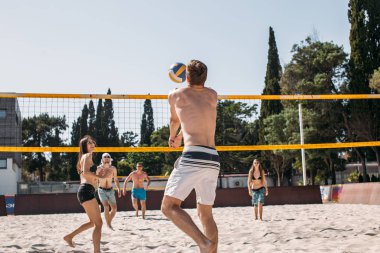 Sahilde voleybol oynayan bir grup dinlenme grubu.