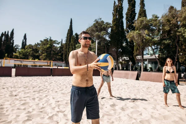 Voleibol praia jogador masculino se preparando para servir a bola na quadra de praia. — Fotografia de Stock