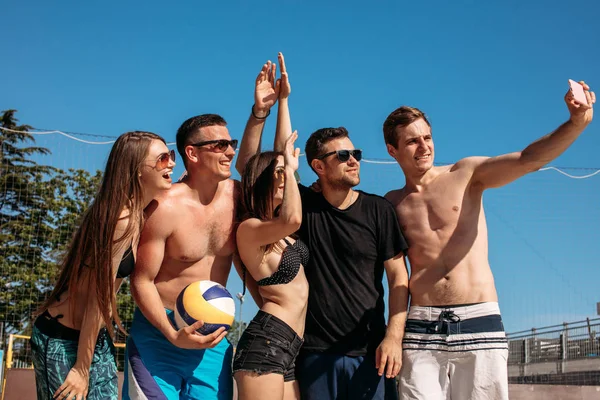 Grupo de amigos europeus sorridentes fazendo selfie na praia — Fotografia de Stock
