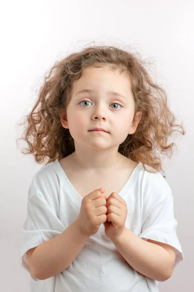 Pretty girl with long vawy hair and clenched fists looking at the camera — Stock Photo, Image