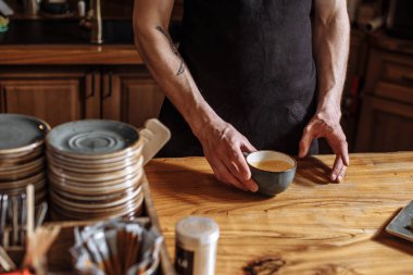 adam bir bardak kahve kabuklarıyla tutuyor