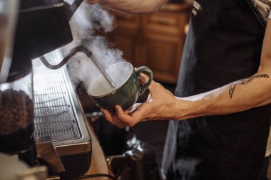 Genç erkek barista kahve makinesi kullanarak süper kahve hazırlama