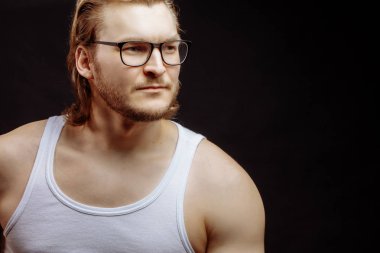 Gözlüklü, açık renk saçlı, dalgın bakışlı bir sporcunun yan görüntüsü.