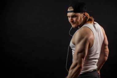 Arkadan çekilen uzun sarı saçlı, güçlü adamın görüntüsü.