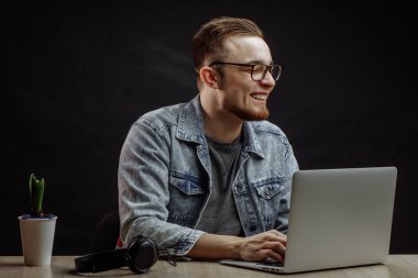 Kızıl saçlı genç adam defterin önünde eğleniyor.