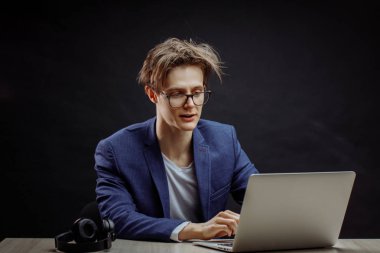 Uzun kahverengi saçlı, bilgisayar kullanan komik bir genç adam.