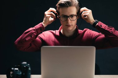 Sarışın fotoğrafçı kulaklık takıyor.