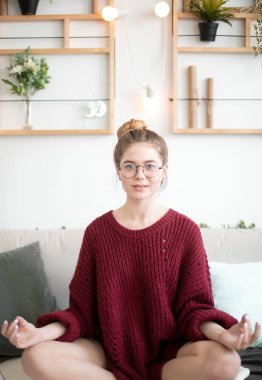 Evde meditasyon yapan güzel bir kadın.