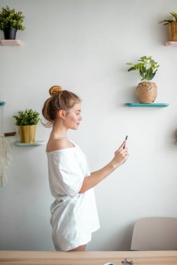 Güzel genç bir kadın evde fotoğraf çekiyor. kenar görünüm fotoğrafı