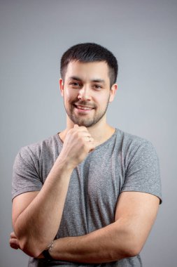 Normal kıyafetli, yapılı bir adam gibi gülümsüyor.