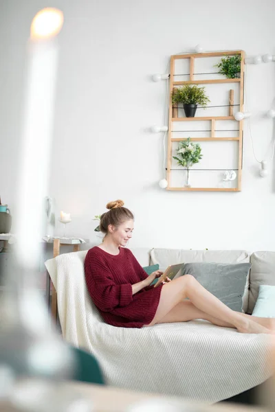 Молодая радостная женщина смотрит на скрижаль в помещении — стоковое фото
