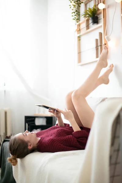 Empresária com tablet está levantando as pernas cansadas após o dia de trabalho — Fotografia de Stock