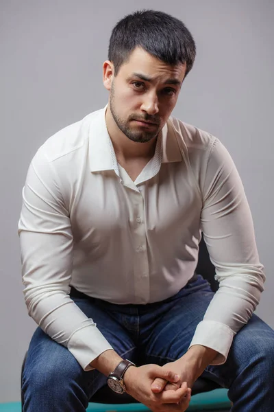 a handsome man in formal clothes resting on the chair