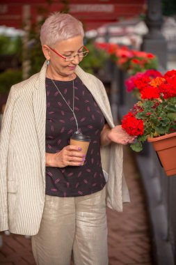 Modern kahve dükkanının iç kısmında duran muhteşem bir iş kadını.