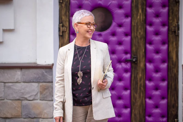 stylish businesswoman is looking back while strolling on the street