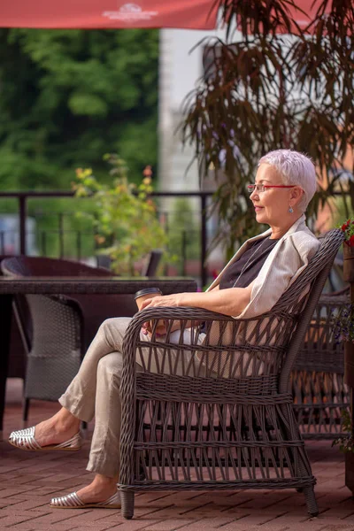 Glad kvinna som har kaffe paus i uteserveringen — Stockfoto