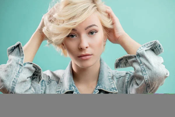 Stylish awesome blond girl touching her hairstyle — Stock Photo, Image