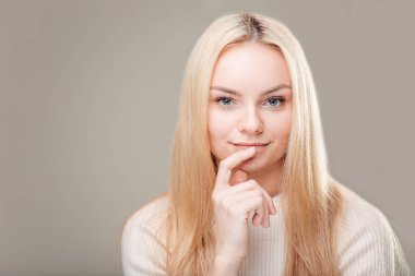 uzun kıvırcık saçlı ve dudak parmağında gülümseyen flört kadın