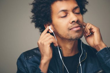 Kulaklık müzik dinlemek gülümseyen mutlu Afrika adam. Beyaz arka plan.