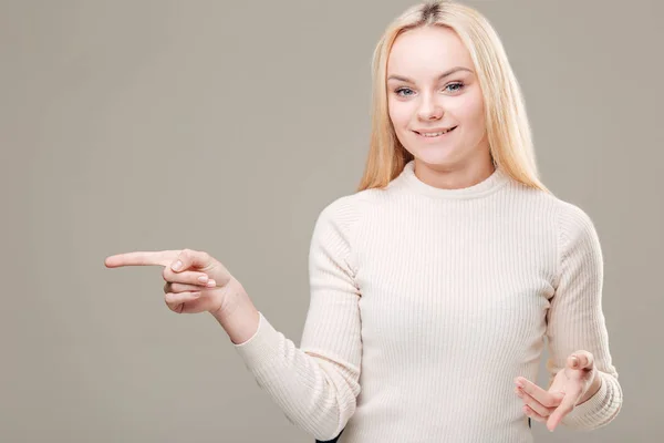 Giovane donna elegante che punta a sfondo bianco — Foto Stock