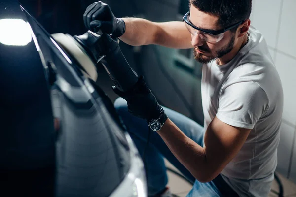 Detalles del coche - hombre con pulidor orbital en taller de reparación de automóviles. Enfoque selectivo . — Foto de Stock