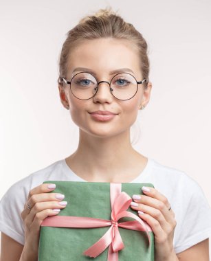 kameraya bakarak Noel hediye ile büyüleyici bir genç kadın