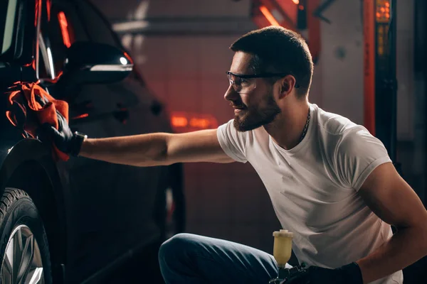 Uomo pulizia auto con panno in microfibra, auto dettaglio o valeting concept — Foto Stock