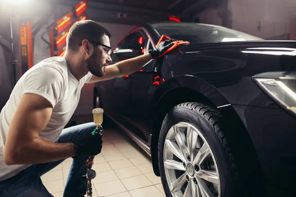 Auto-Detaillierung - der Mann hält die Mikrofaser in der Hand und poliert das Auto — Stockfoto