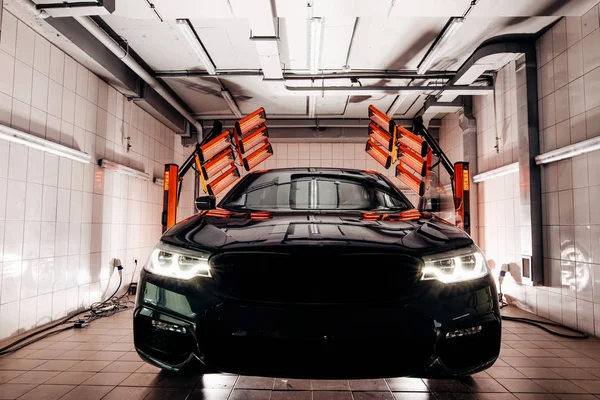 Lampen voor het drogen van de keramische coating zijn achter de auto — Stockfoto