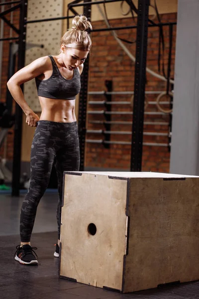 Fit beautiful woman is standing in front of the box at gym — Stock Photo, Image