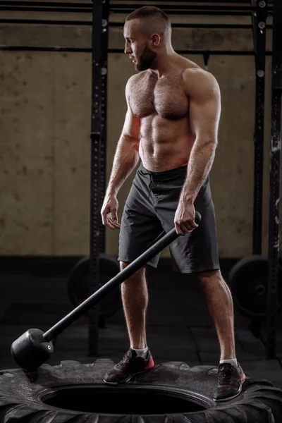 Muskulös bar överkropp man med hammare tittar åt sidan — Stockfoto