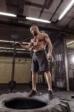 güçlü kas adam büyük lastik üzerinde dinleniyor