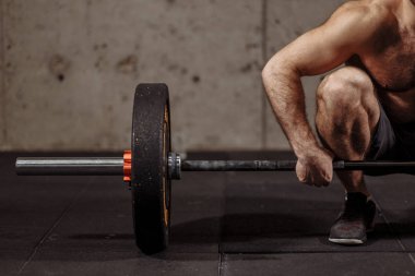 Atletik gömleksiz genç adam egzersiz halter salonunda ile yapmak.
