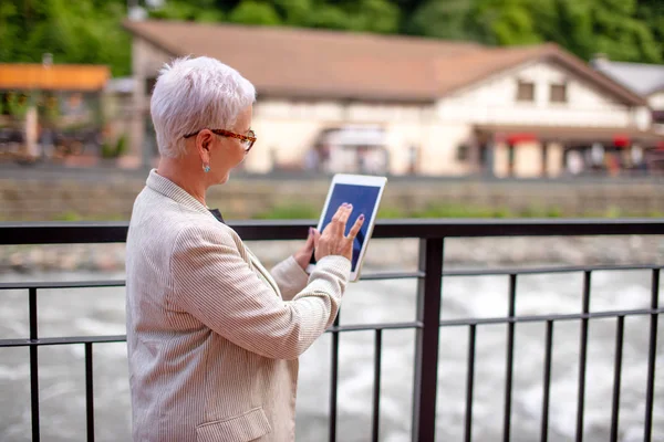 Tillbaka Visa foto av senior kvinna söka vägen i navigator — Stockfoto