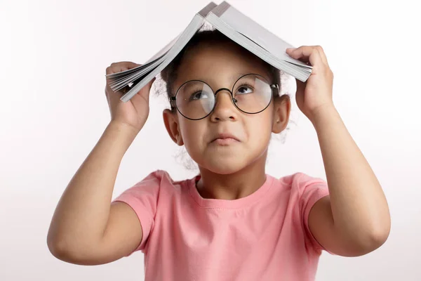 African funny girl with a book is making faces — Stock Photo, Image