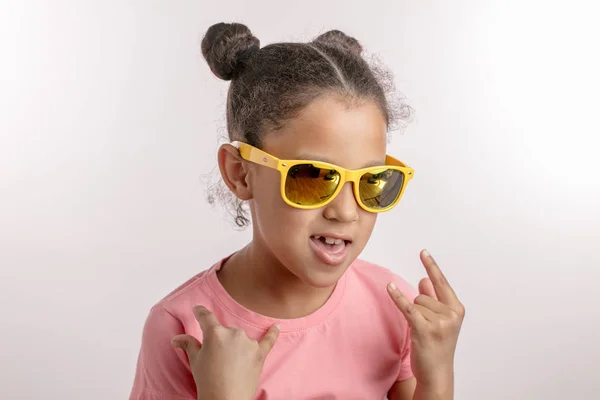 En cool mulatt tjej i solglasögon visar rock gest — Stockfoto