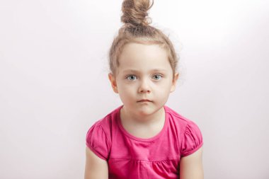 Saç topuz ve kameraya bakarak ciddi bir yüz ile sevimli şirin kız