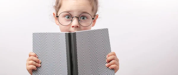 Fille craintive couvre son visage avec un livre — Photo
